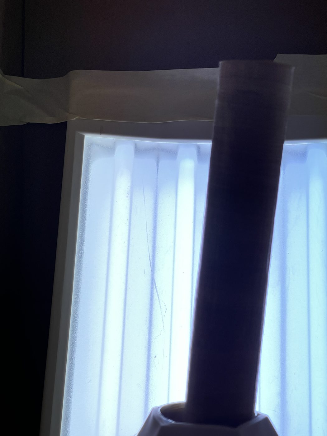 The baked scroll standing dark against the light box